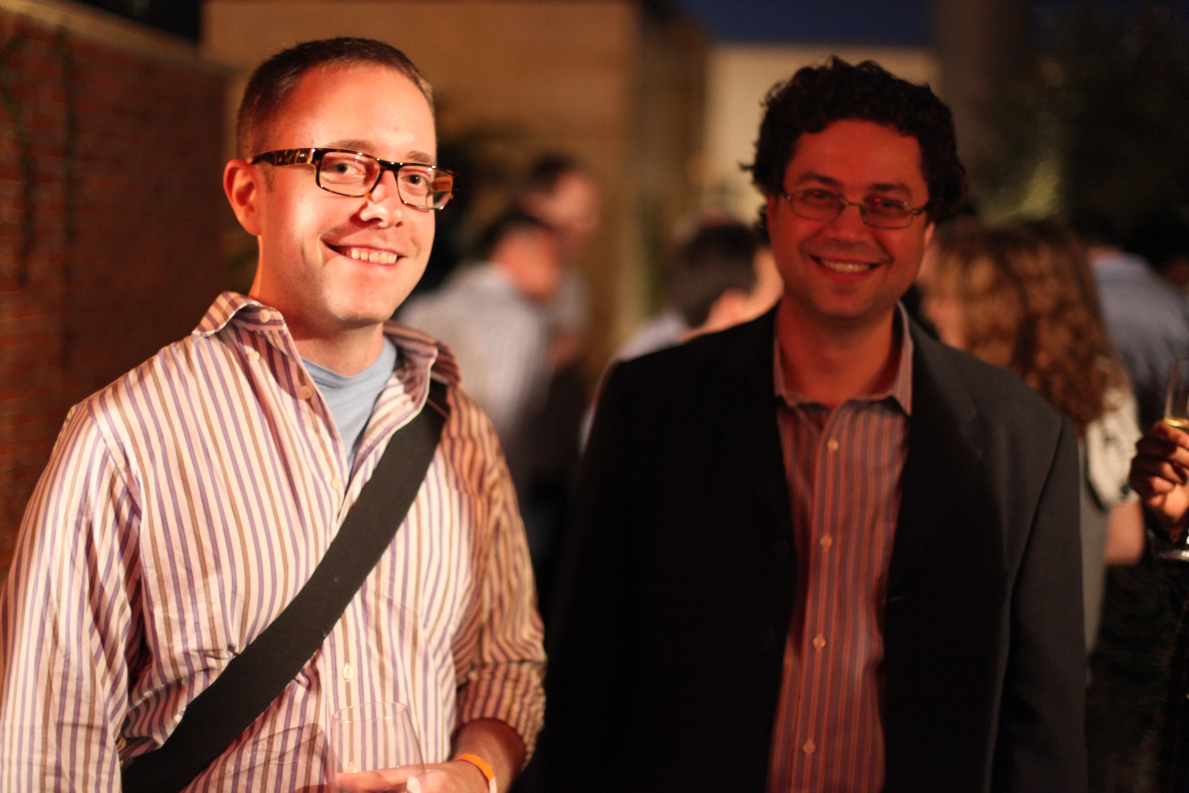 two men standing next to each other wearing glasses