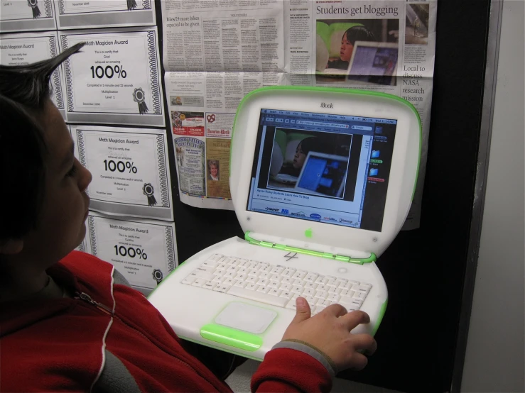 a  using a laptop computer while sitting in front of papers