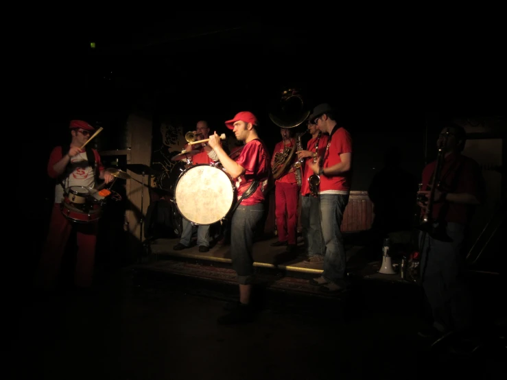 a band playing and standing on stage at night