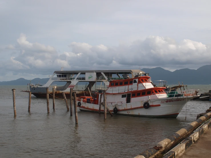 a large white and orange boat next to dock