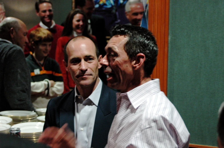 two men smiling for the camera at a dinner