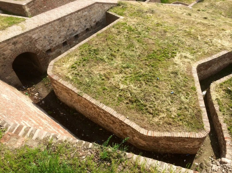 a brick structure with grass on top of it