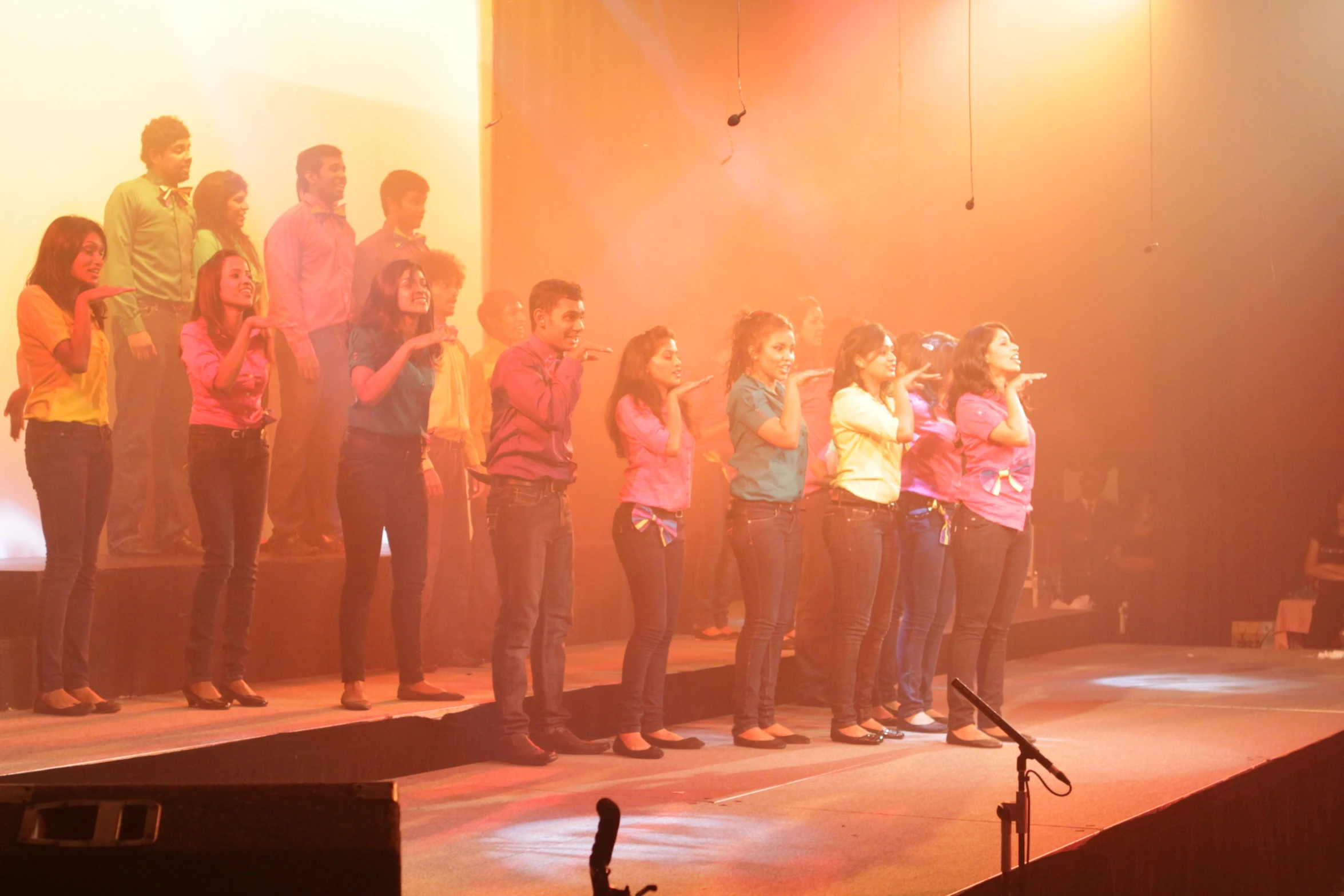 group of young people singing on stage with microphones