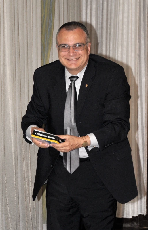 an older man in a suit holding a hard rock