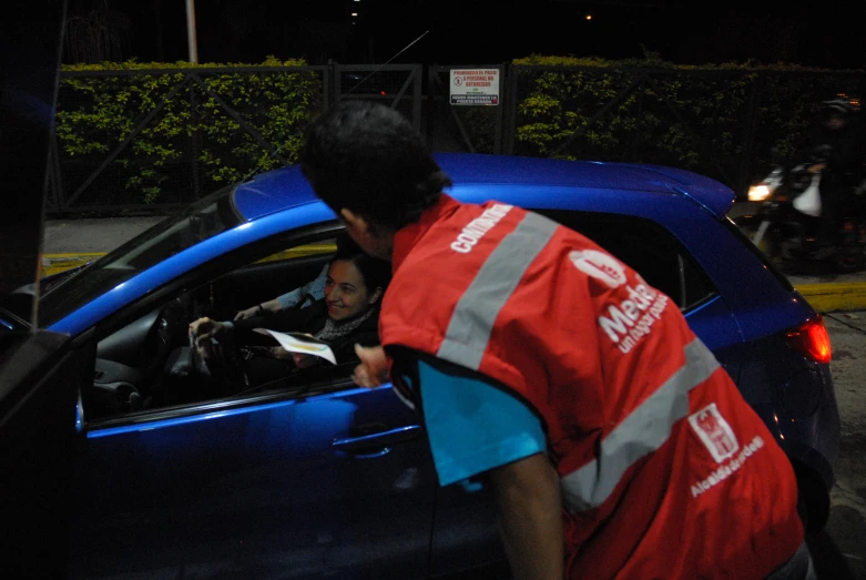 an employee helps a driver in her vehicle