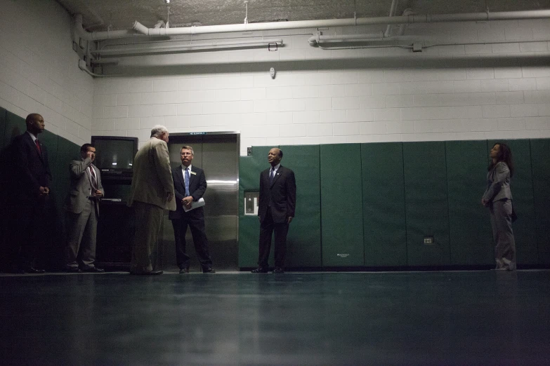 some men in suits and ties standing near an elevator