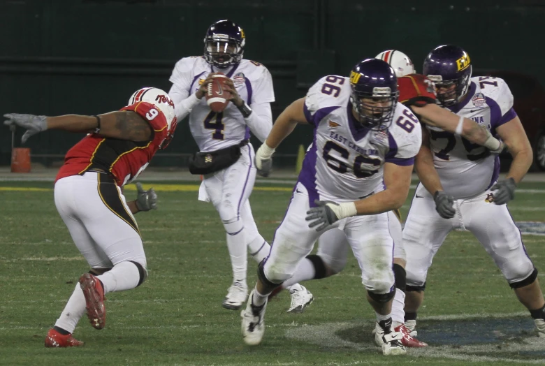 two opposing football teams are running for the ball