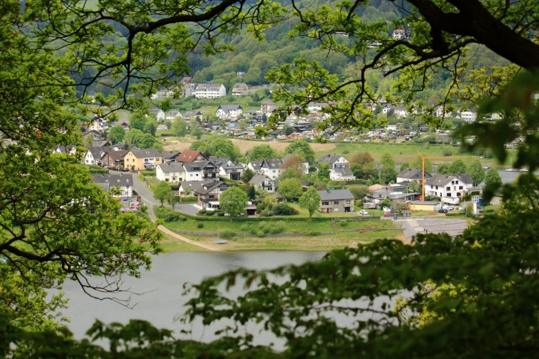 a view of houses sitting on a hill by the water