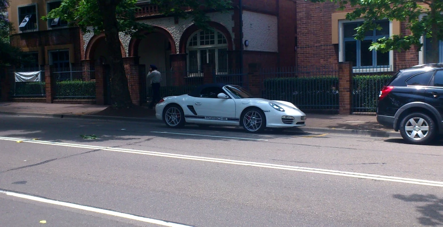 a white porsche on the side of a road