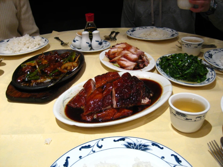 a table with many plates and bowls of food