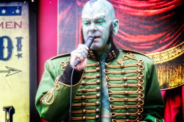 a man dressed in green performing on stage