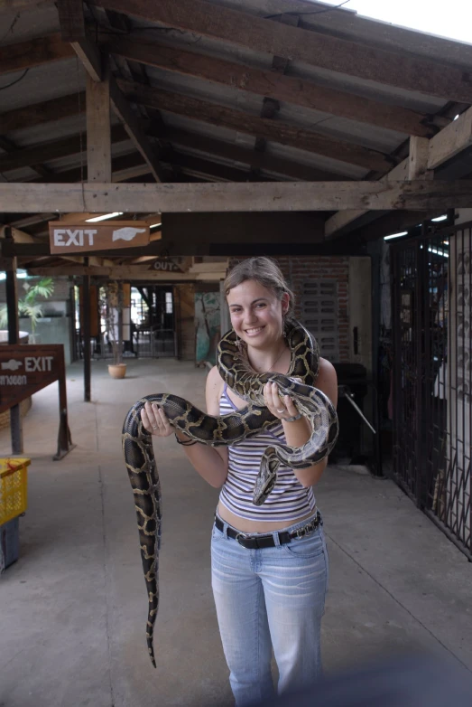 there is a woman holding a snake in a building