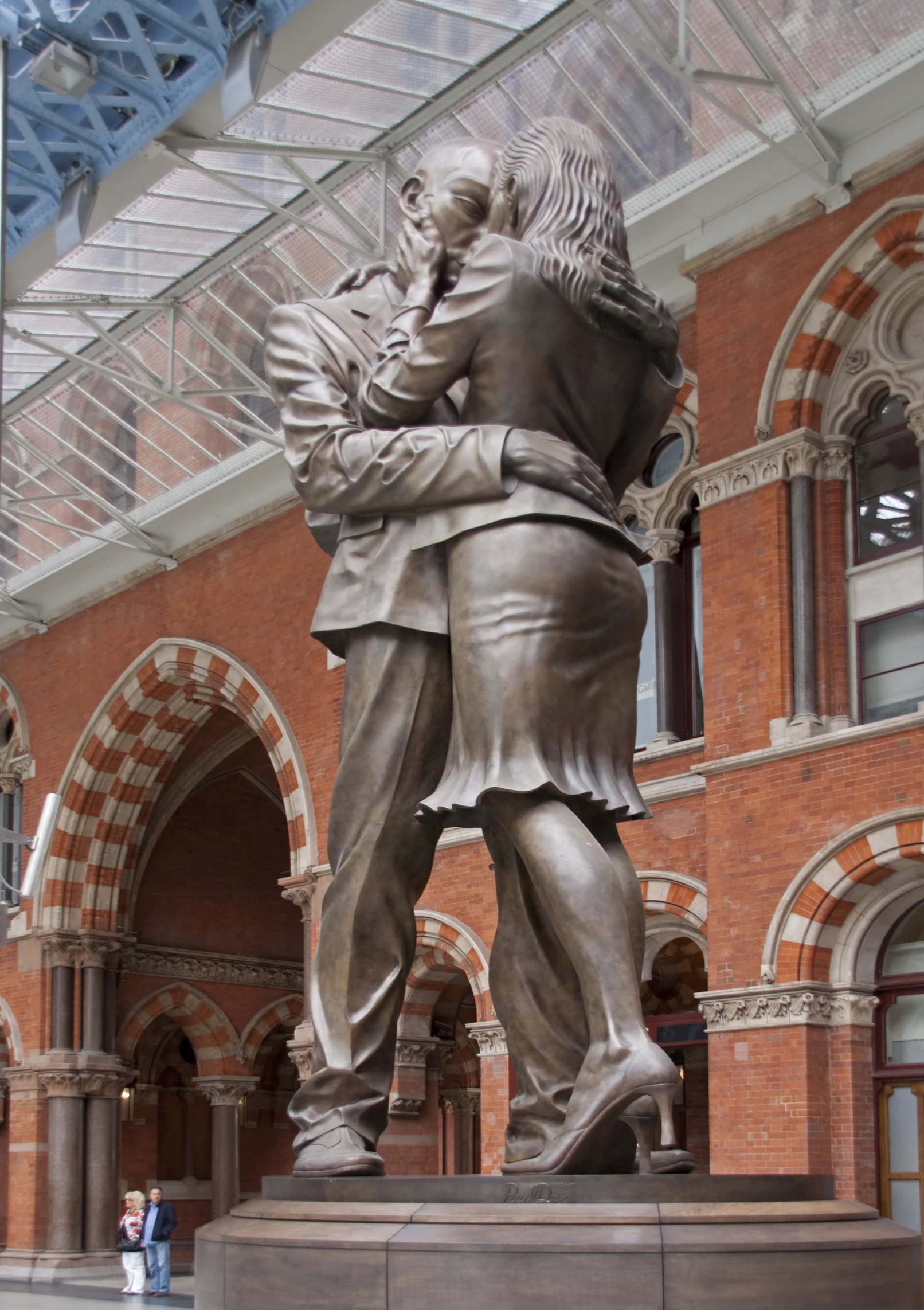 a statue of two men hugging in front of a building