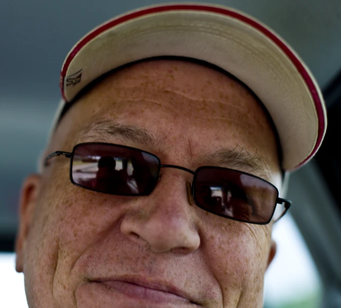 an older man wearing sunglasses while he is taking a selfie