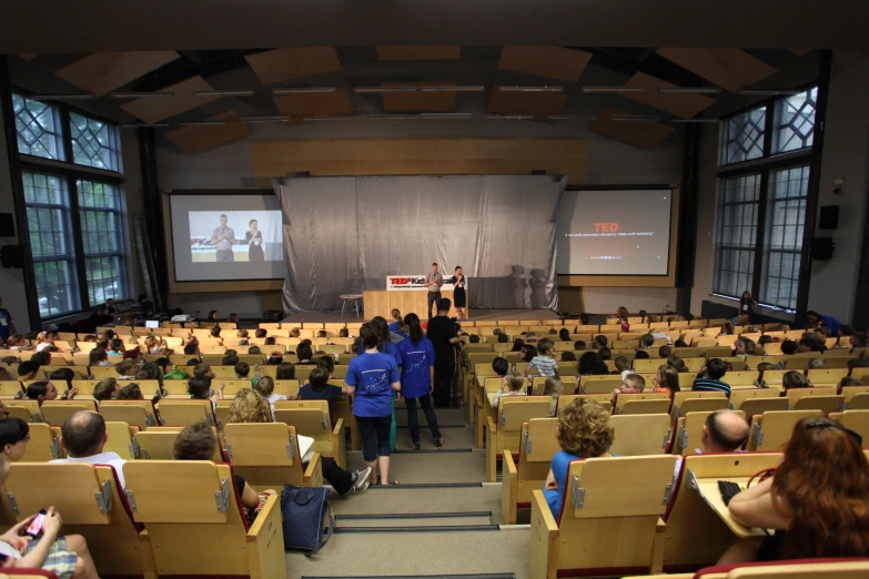 large room with large students listening to their speakers