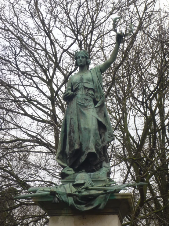 statue of lady justice surrounded by trees in park