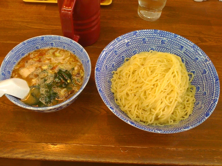a couple of bowls of noodles next to one another
