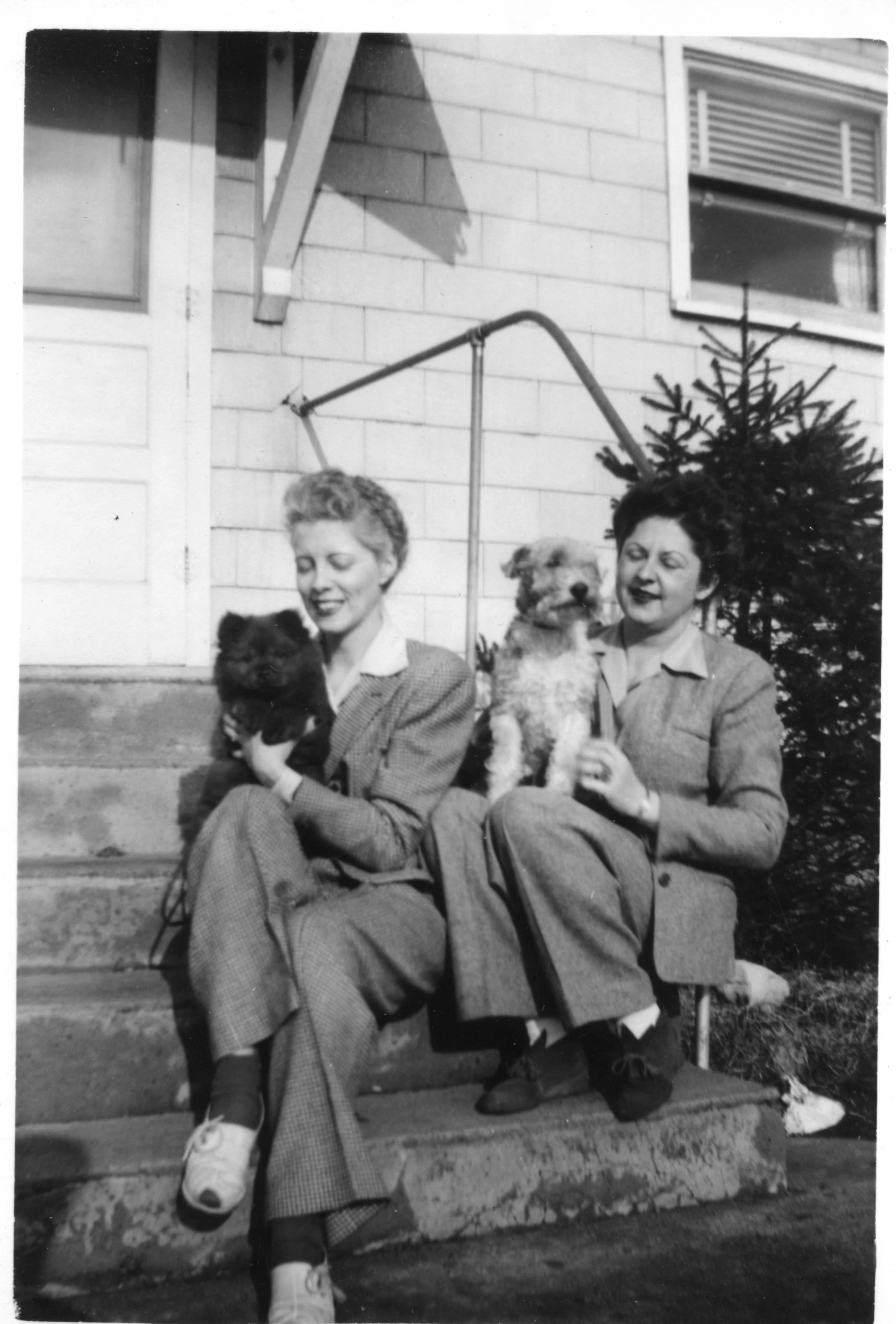 a black and white po shows two women with small dogs