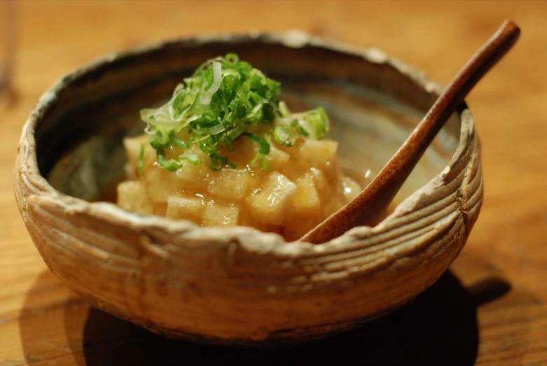 an empty bowl with wooden spoon on a wooden table