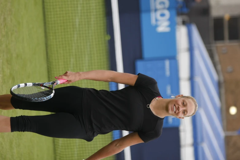 woman on tennis court holding racquet on grass field