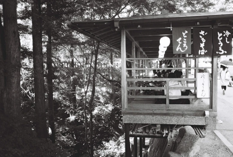 an asian shrine with trees and signs hanging in it