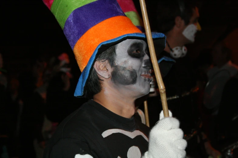 a person with painted faces holding a broom