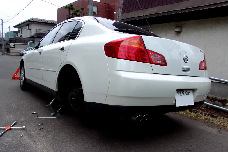 a white car parked in front of a building next to other cars