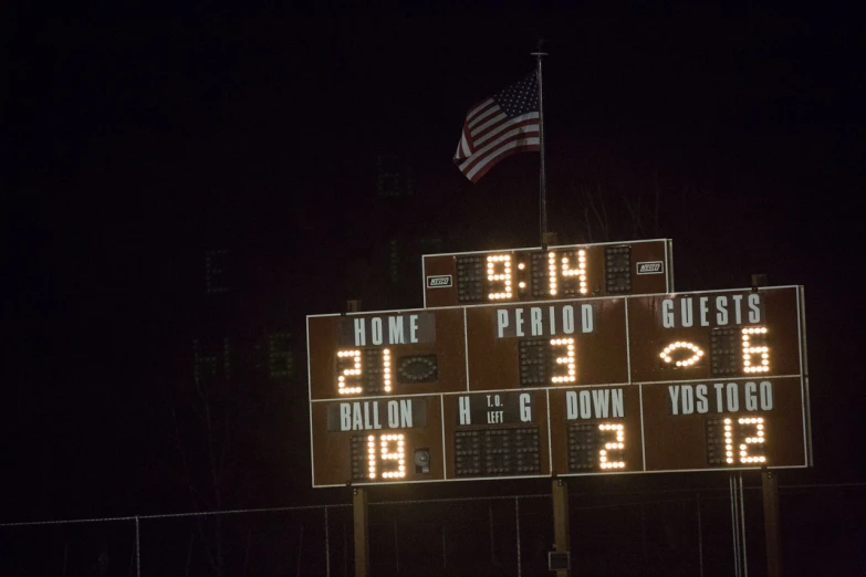 a score board lit up at night with the number of players