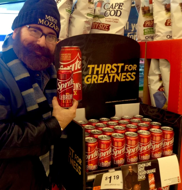 a man is holding up a can of canned beer