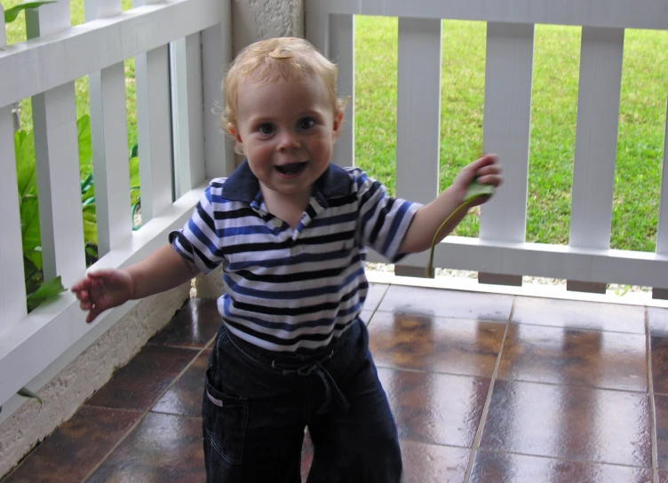 a  standing on a deck in front of a fence