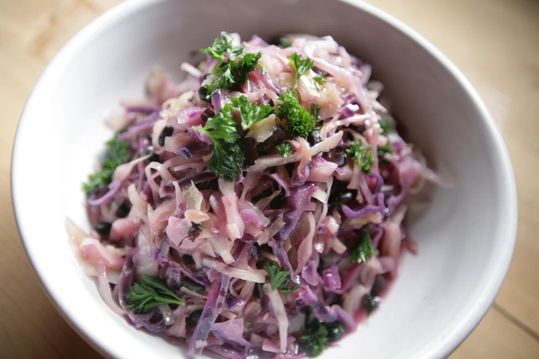 a white bowl containing red cabbage and parsley