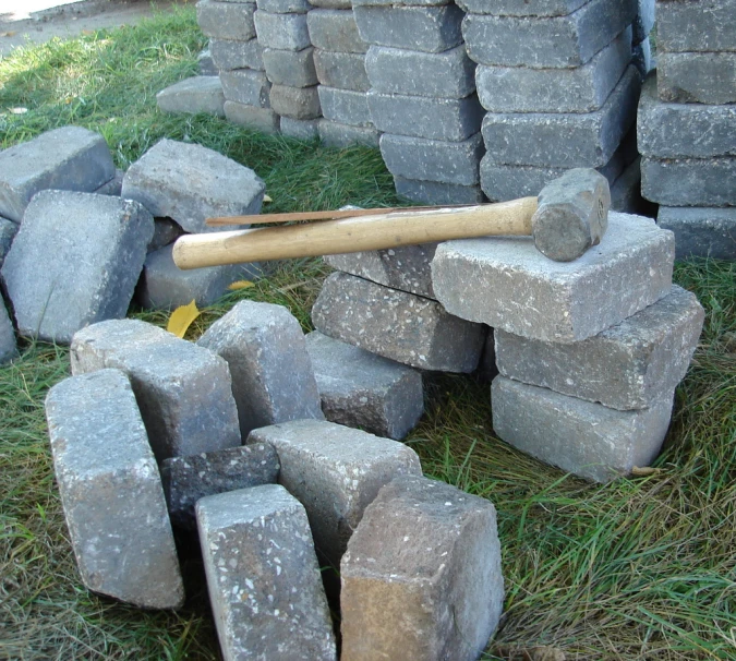 a wooden baseball bat standing on top of a pile of rocks