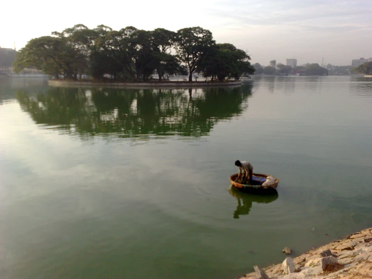 two people in a small boat paddling on the water