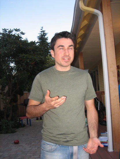 a man is standing on a patio with his hands out