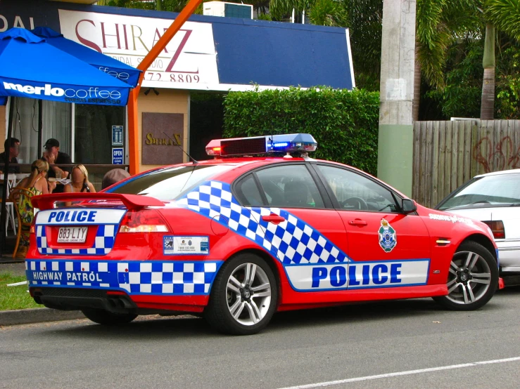 a red police car that is parked on the side of the road
