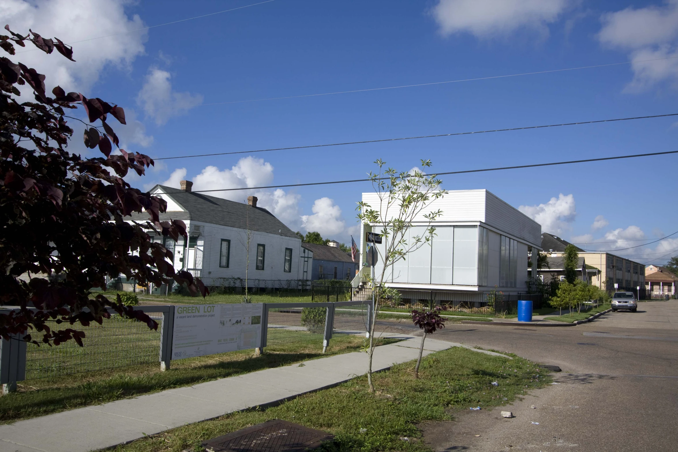 a house with white walls and doors next to a road