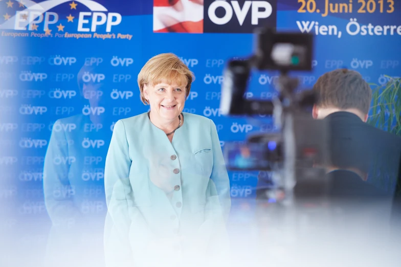 the german woman smiles as she speaks on stage