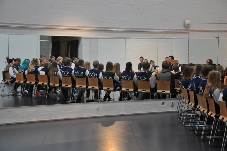 a large group of people sitting in chairs in a room