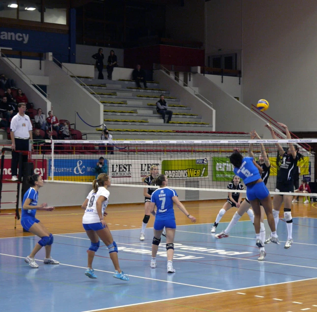 a group of people on a court playing volleyball