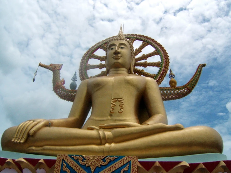 a large gold statue is in the midst of clouds