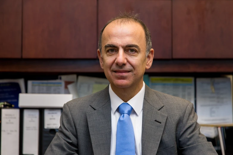 a man in suit and blue tie in an office