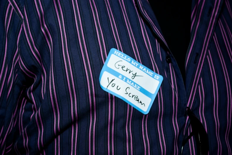 a person with a name tag on their blue pinstripe shirt