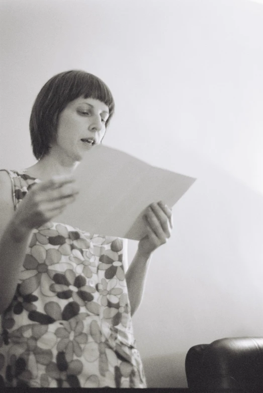 a woman holding a piece of paper and looking at it