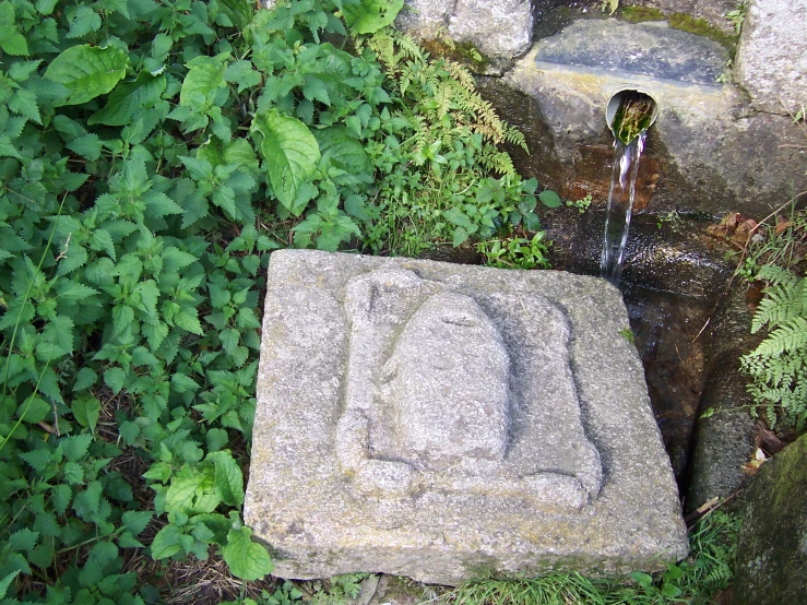 a garden fountain sits next to a rock