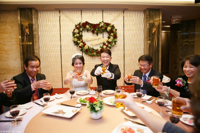 a wedding party posing for a po while they toast