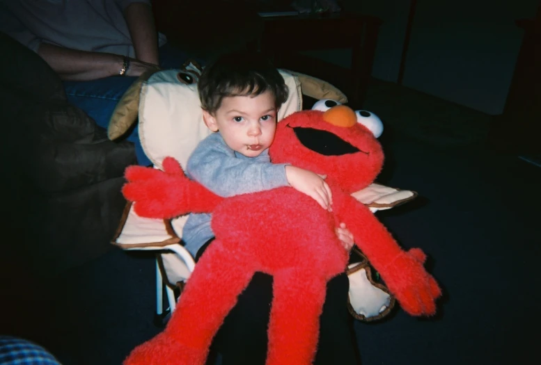 a child cuddles with sesame the creator stuffed animal