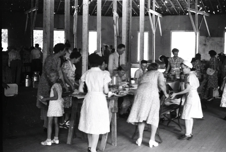 a group of people with a large table filled with food