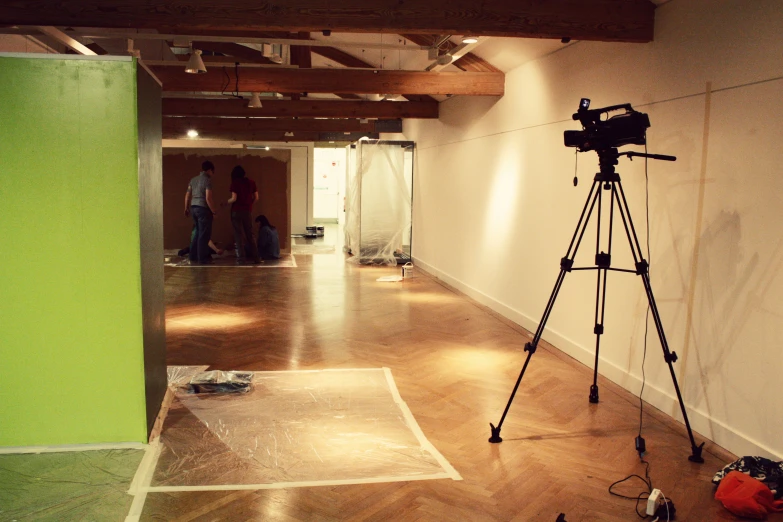 two men are talking in a hallway with a video camera