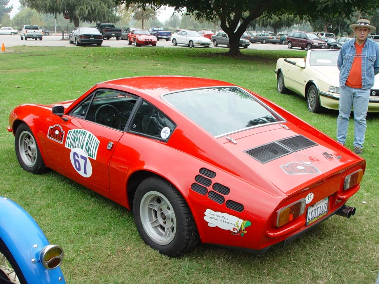 an old style sports car is parked on the grass
