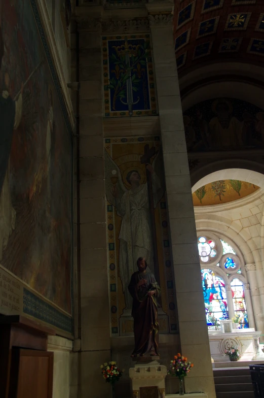 a tall church ceiling with paintings of people and stained glass windows